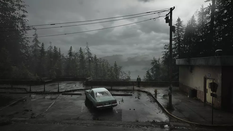 A car parked beside a public restroom with a person looking out over a lake