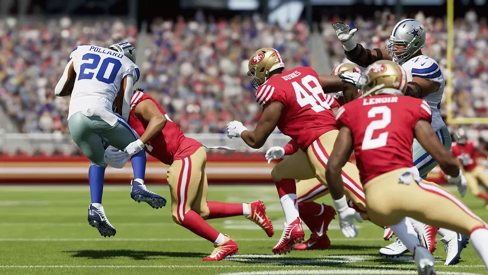 Tony Pollard being tackled by 49ers players.