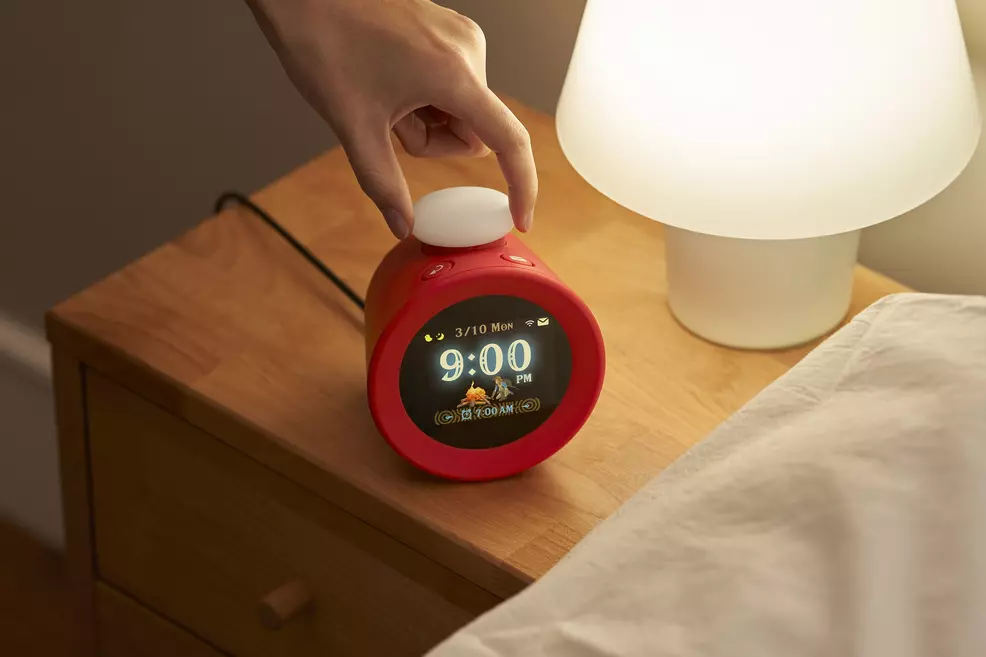 Nintendo Sound Clock Alarmo placed under a lamp at bedside
