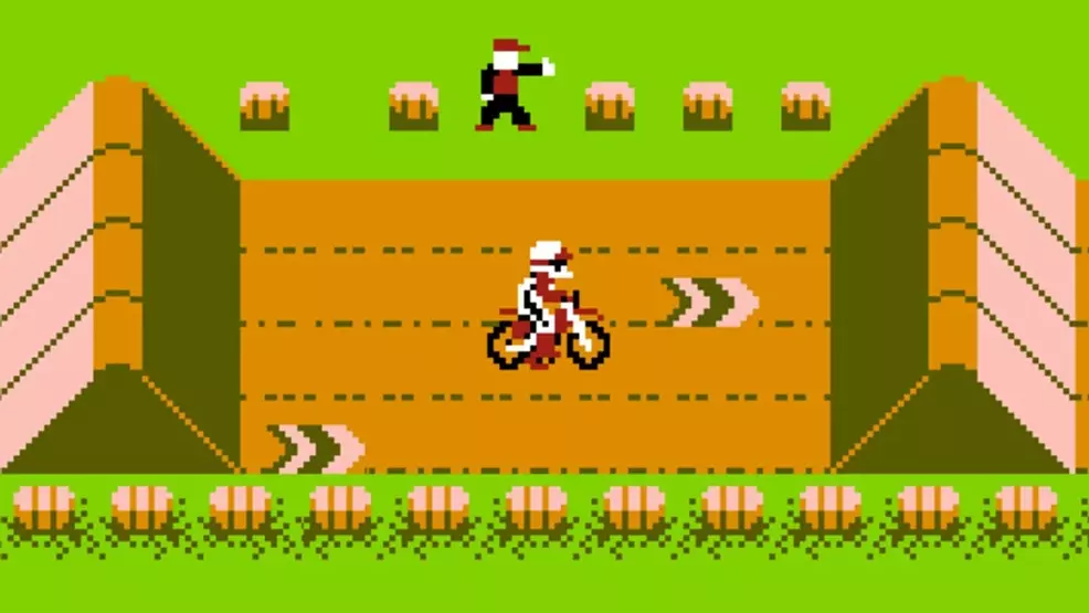 A racer driving a dirtbike between ramps in Excitebike on NES.
