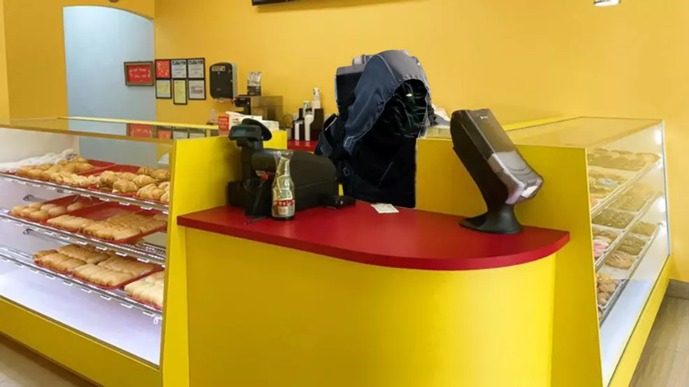 Xur behind the counter of a donut shop.